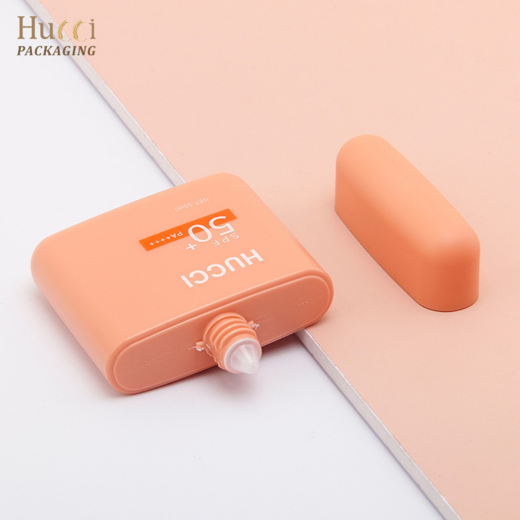 50ml Peach PE Square Sunscreen Bottle Lying Flat with Detachable Cap Pink White Split Background Top View}