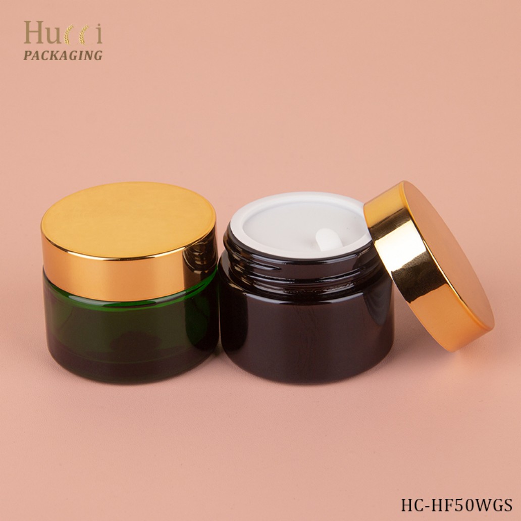 HUCCI 50ml Amber & Green Glass Face Cream Jars with Shiny Gold Lids & PP Inner Sealers Pink Background Display}