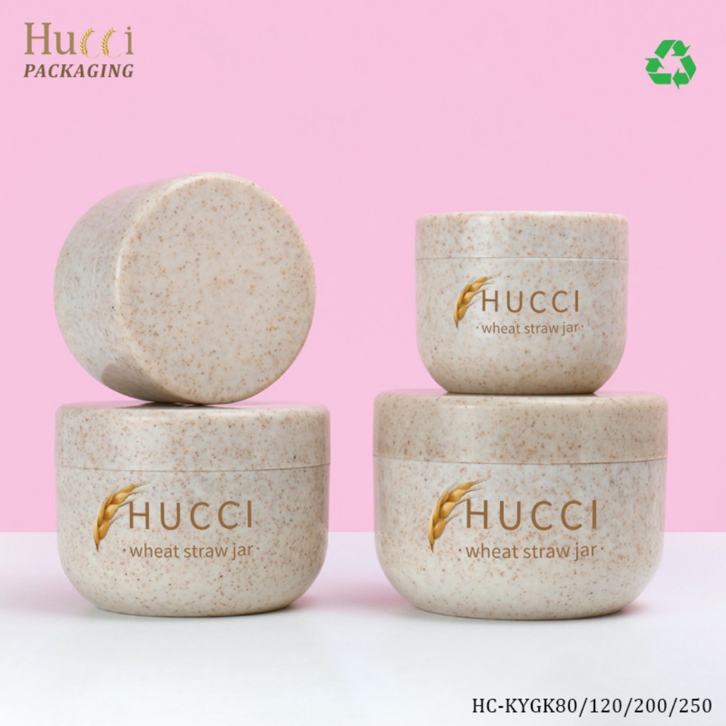 Two Sizes of HUCCI Wheat Straw PP Cream Jars Stacked Closed Pink Background with Eco Recycling Logo