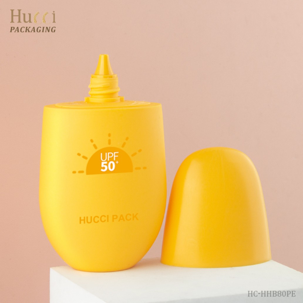 HUCCI Yellow PP Sunscreen Bottle Opened Nozzle with Cream Application Close-up Pink Background on White Pedestal}