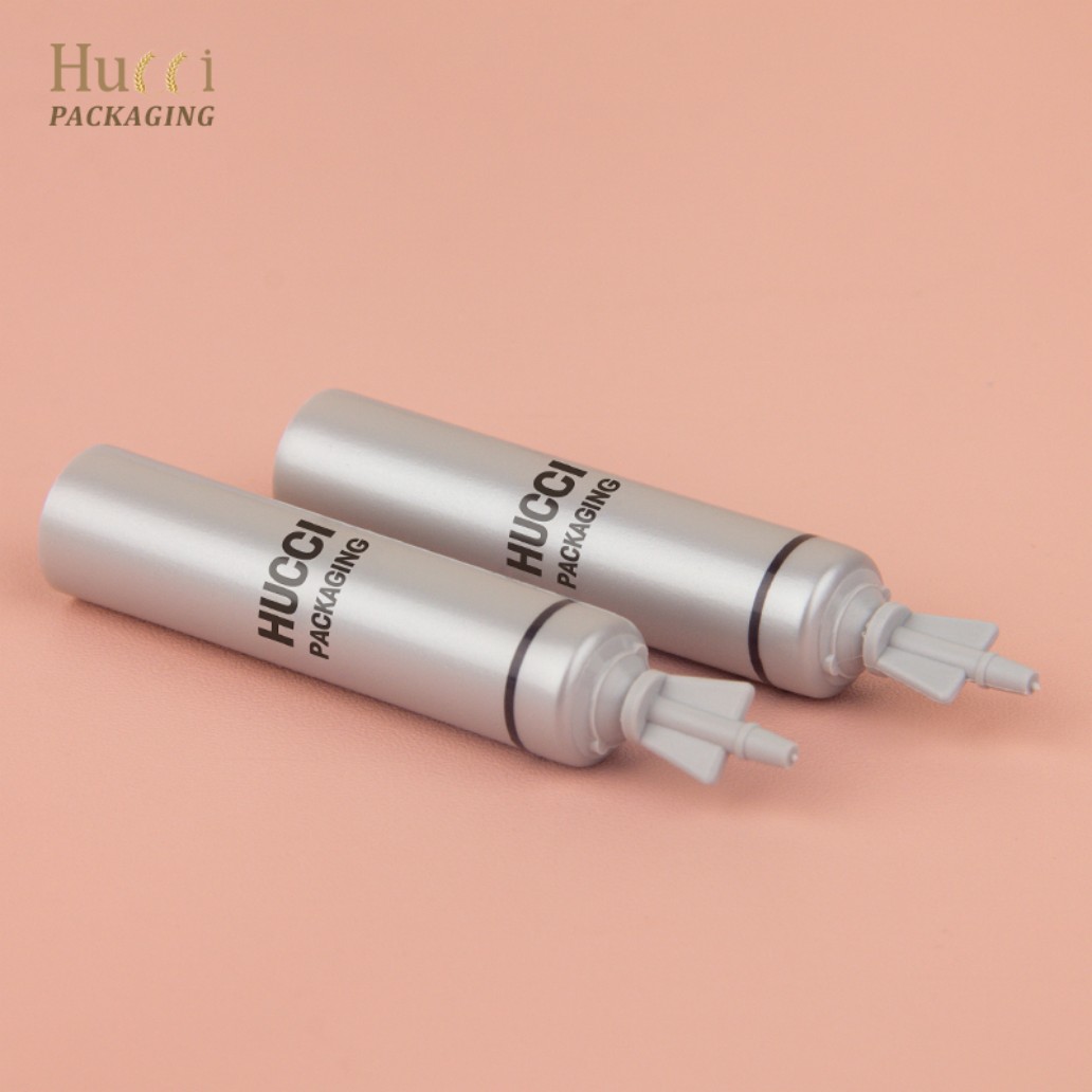 Silver PE Cream Tubes with Long Nozzle Caps on Pink Background, Custom OEM Wholesale Packaging.}